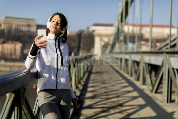 Woman on the bridge making a pause after the exercise Stock photo © boggy