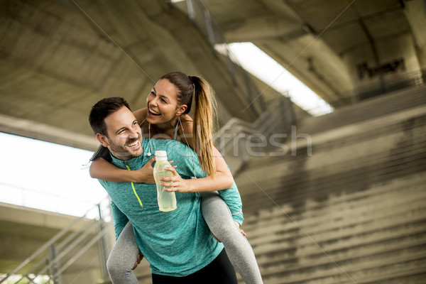 Sportsman holding a sportswoman on his back Stock photo © boggy