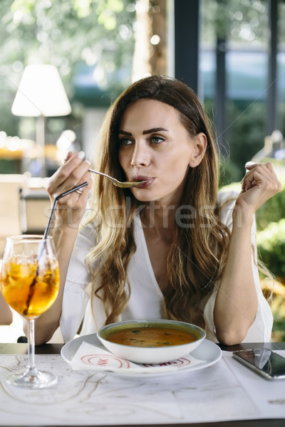 Young woman eating soup in restaurant Stock photo © boggy