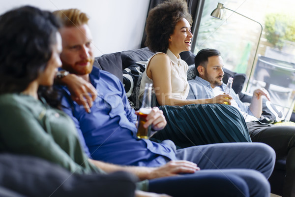 Group of friends watching TV, drinking cider  and having fun Stock photo © boggy