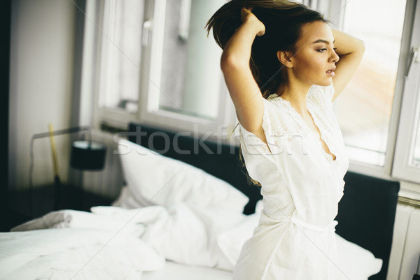 Young woman in the room gets out of bed Stock photo © boggy