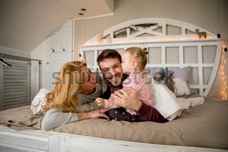 Young Family Having Fun On The Bed Stock Photo C Goran