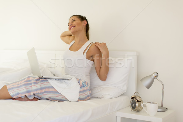 Donna laptop letto donna sorridente up Foto d'archivio © boggy