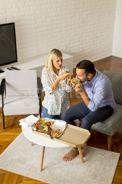 Couple relaxing at home and eating tasteful pizza Stock photo © boggy