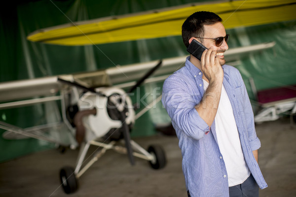 Stockfoto: Knap · jonge · piloot · vliegtuig · mobiele · telefoon · technologie