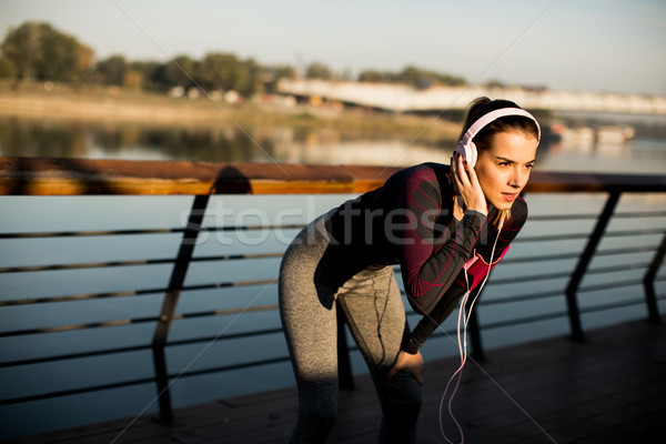 Young woman exercises on the promenade after running Stock photo © boggy