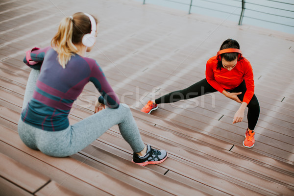 Young woman exercising with a personal trainer outside Stock photo © boggy