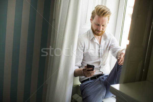 Człowiek broda czerwony smartphone odpowiedzieć bałagan Zdjęcia stock © boggy