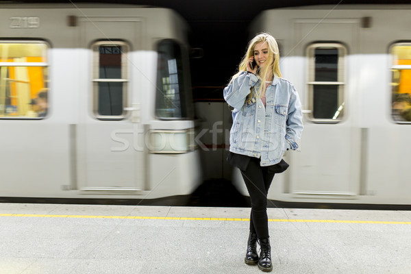 Młoda kobieta czeka pociągu podziemnych dziewczyna telefonu Zdjęcia stock © boggy