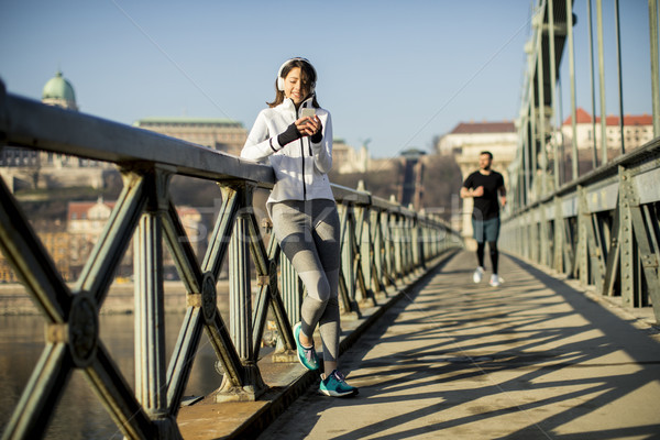 Woman on the bridge making a pause after the exercise Stock photo © boggy