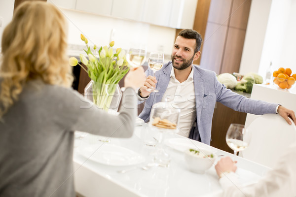 Young couple sitting in the kitchen  and drinking white wine Stock photo © boggy