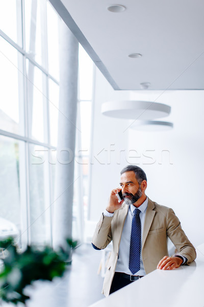 Stock photo: Handsome mature businessman  with mobile phone