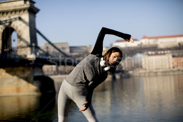 Woman in sportswear stretching on Danube river promenade in Buda Stock photo © boggy