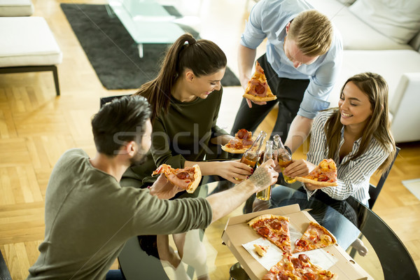 Young people eating pizza and drinking cider in the modern inter Stock photo © boggy