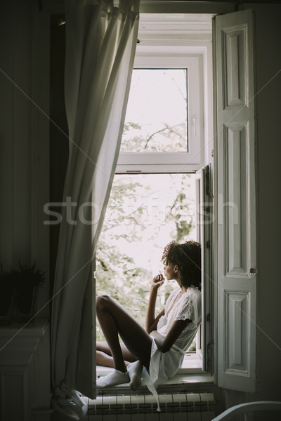 Ziemlich jungen schwarze Frau Sitzung Fenster Zimmer Stock foto © boggy
