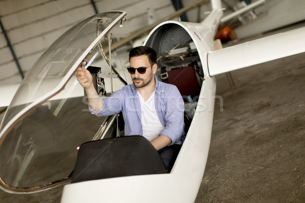 Handsome young pilot checking his ultralight airplane before fli Stock photo © boggy