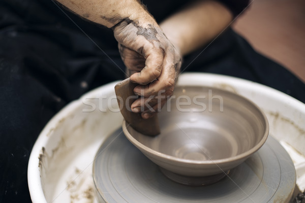 Artist makes clay pottery on a spin wheel Stock photo © boggy