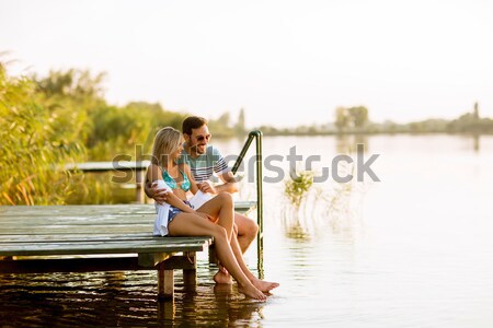 Group of young people having fun on pier at the lake Stock photo © boggy