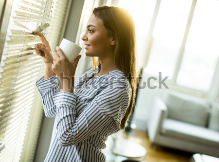 Fiatal nő göndör haj ház nyitva üveg ajtó Stock fotó © boggy
