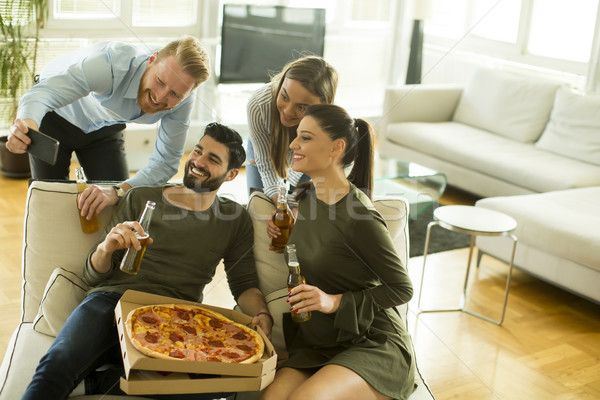 Young people eating pizza, drinking cider and taking selfie in t Stock photo © boggy