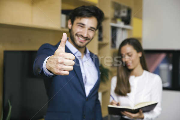 Young businessman with thumb up standing with businesswoman in o Stock photo © boggy