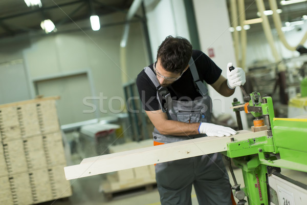 Young man works in a factory for the production of furniture Stock photo © boggy