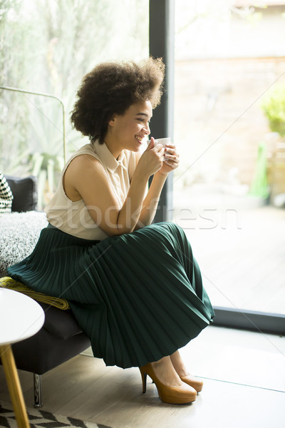 Afro-amerikaanse vrouw vergadering sofa beker koffie Stockfoto © boggy