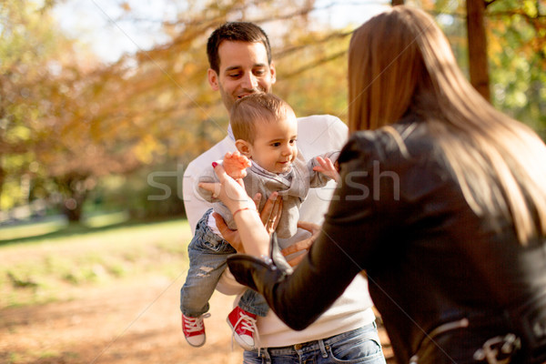 Happy young parents with baby boy in autumn park Stock photo © boggy