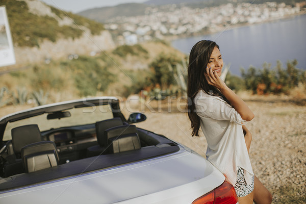 Młoda kobieta telefonu komórkowego stałego kabriolet samochodu hot Zdjęcia stock © boggy