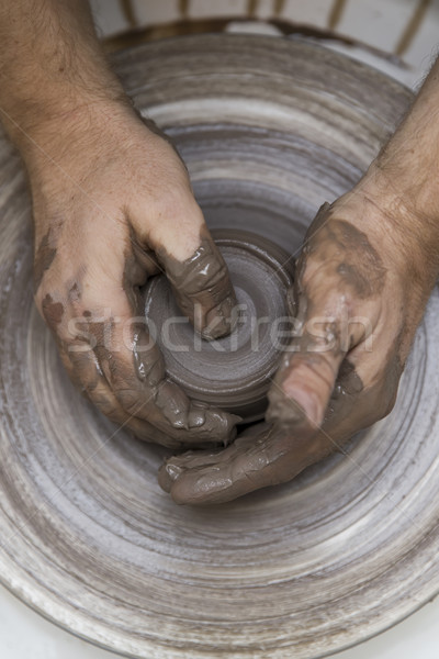 Artist makes clay pottery on a spin wheel Stock photo © boggy