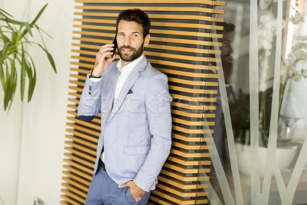 Modernen Geschäftsmann gut aussehend Anzug halten Telefon Stock foto © boggy