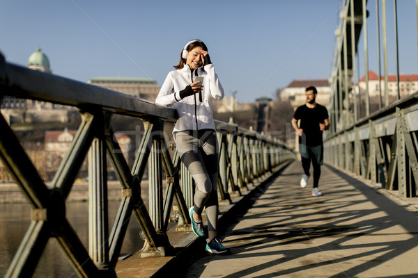 Woman on the bridge making a pause after the exercise Stock photo © boggy