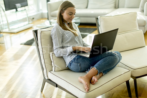Smiling With A Laptop Lying On A Sofa In Living Smiling With A Laptop Lying On A Sofa In Living