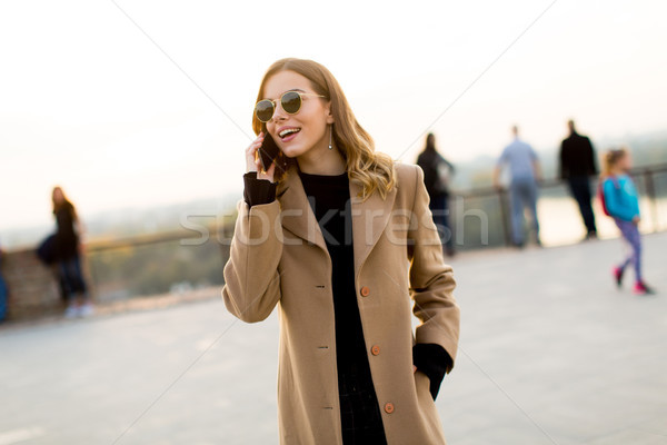 Young woman with eyeglasses with mobile phone outdoor Stock photo © boggy