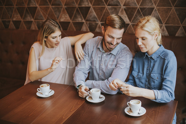 Zwei Frauen Mann Kaffeehaus sprechen lachen genießen Stock foto © boggy