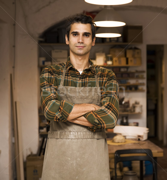 Handsome young man posing in pottery workshop Stock photo © boggy