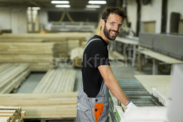Przystojny młody człowiek pracy tarcica fabryki meble Zdjęcia stock © boggy