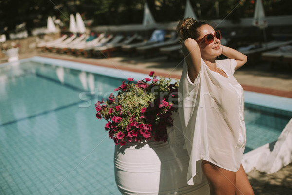 Young woman standing next to the swimming pool Stock photo © boggy