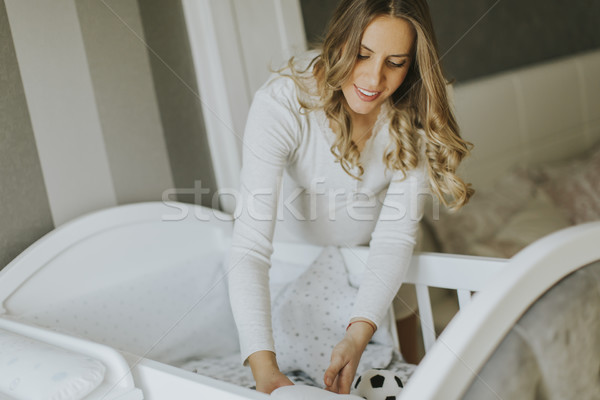 Pregnant woman setting up baby crib Stock photo © boggy