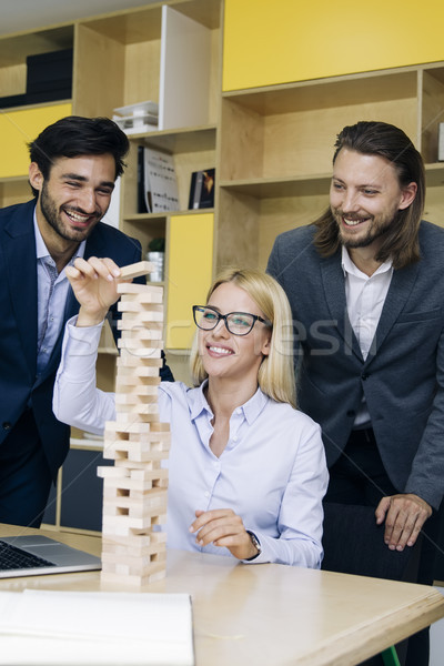 Team of young business people build a wooden construction Stock photo © boggy
