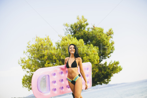 Jeune fille matelas plage eau fille soleil Photo stock © boggy