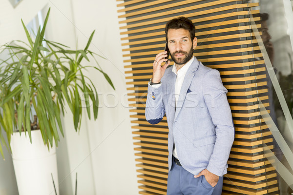 Modernen Geschäftsmann gut aussehend Anzug halten Telefon Stock foto © boggy