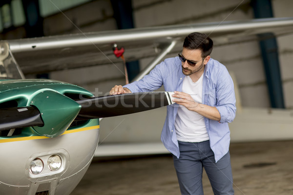Handsome young pilot checking his ultralight airplane before fli Stock photo © boggy