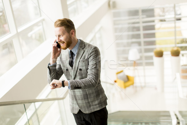 Handsome businessman using smartphone in the office Stock photo © boggy