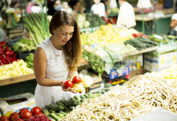 Young woman picking fresh vegetable at the market Stock photo © boggy