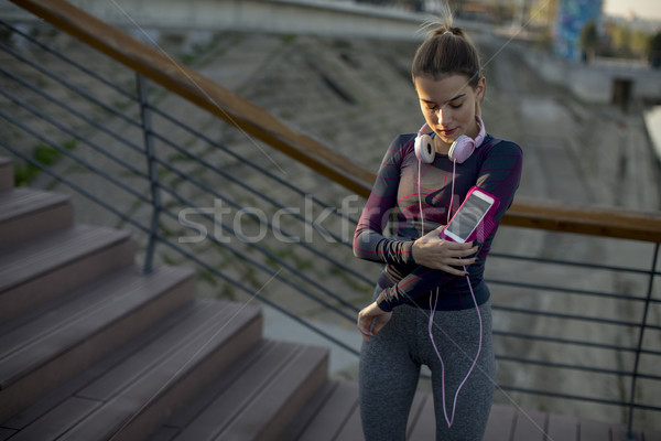 Young attractive female  runner taking break after jogging outdo Stock photo © boggy