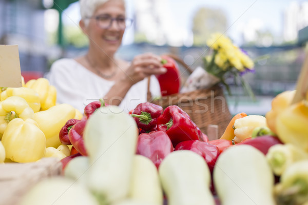 Good-looking senior woman wearing glasses buys pepper on market Stock photo © boggy