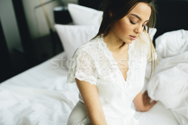 Young woman relaxing in white bed after waking up Stock photo © boggy
