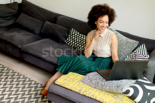 Jonge afro-amerikaanse vrouw internet vergadering sofa Stockfoto © boggy