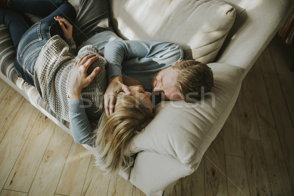 Loving couple lying down on the sofa in the room Stock photo © boggy